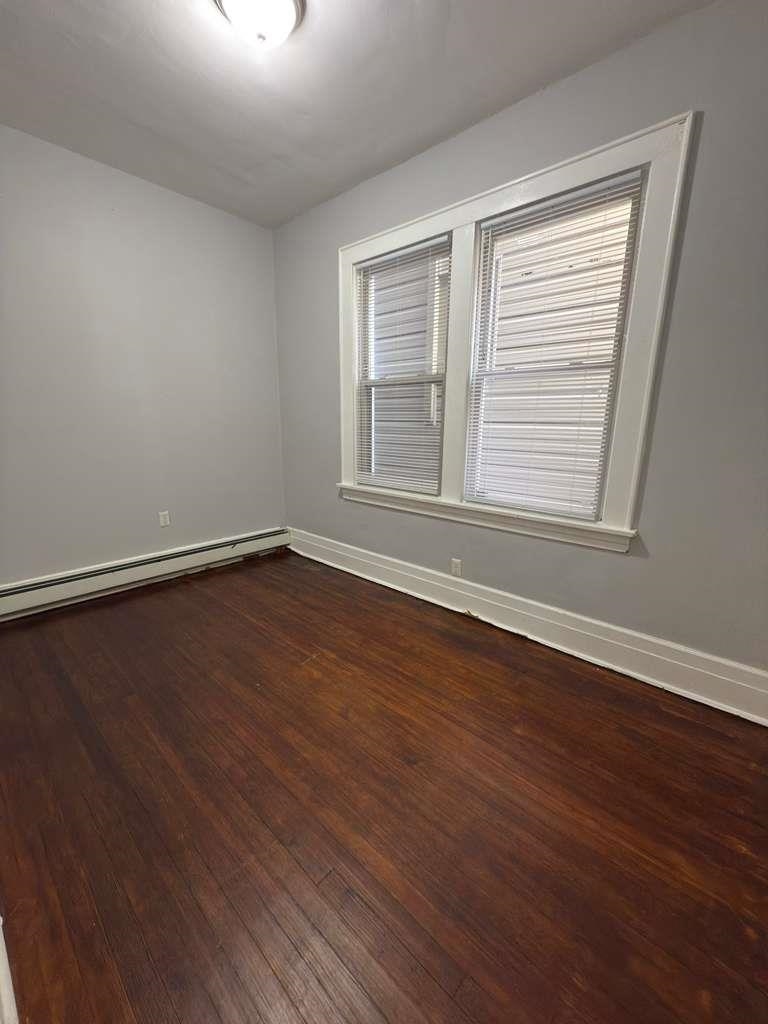 275 Highland Avenue, Unit 1 Kearny, NJ 07032 - Photo 5 of 8 a view of an empty room with wooden floor and a window