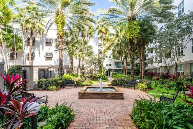 a view of a street with potted plants and large trees