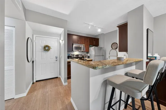 a kitchen with stainless steel appliances granite countertop a refrigerator and a stove top oven