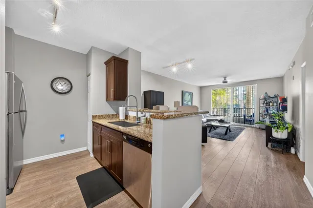 a kitchen with sink a refrigerator and microwave