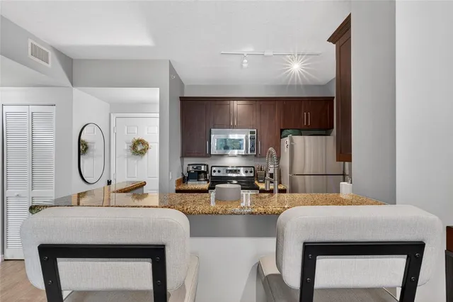 a kitchen with a sink a stove and chairs
