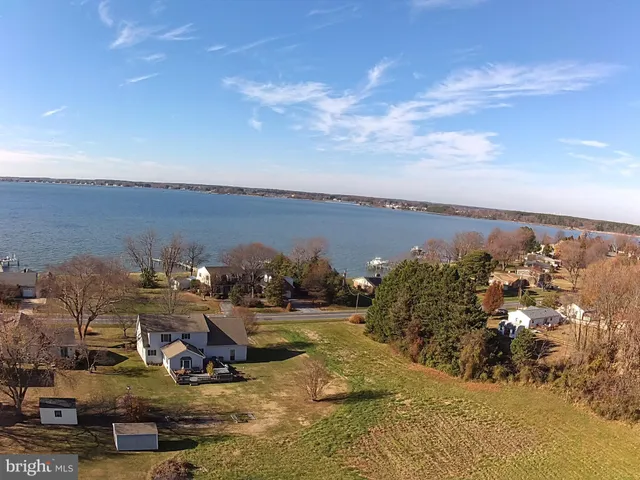 an aerial view of a house with a yard lake and mountain view in back