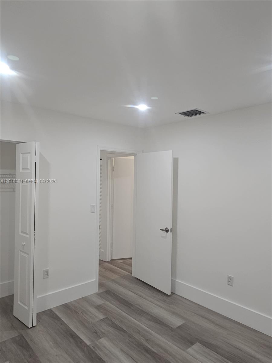 4010 Tree Top Road, Unit 4010 Cooper City, FL 33026 - Photo 11 of 12 an empty room with wooden floor and white wall