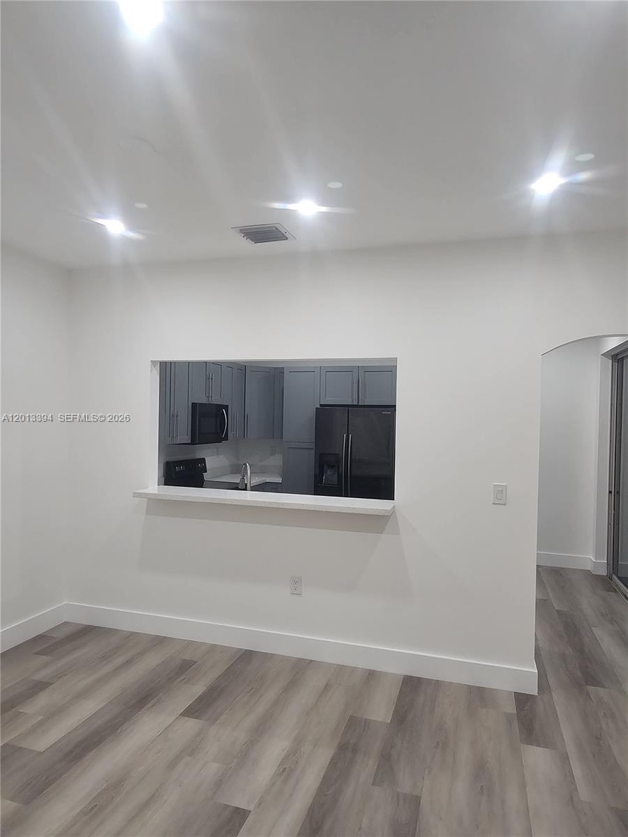 4010 Tree Top Road, Unit 4010 Cooper City, FL 33026 - Photo 2 of 12 an empty room with wooden floor and windows
