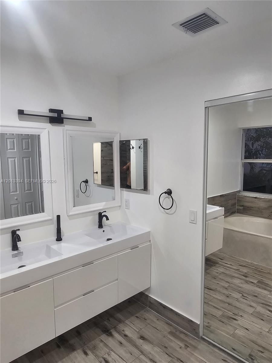 4010 Tree Top Road, Unit 4010 Cooper City, FL 33026 - Photo 7 of 12 a bathroom with a double vanity sink and mirror