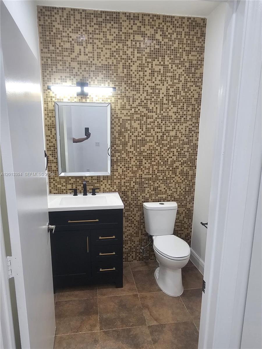 4010 Tree Top Road, Unit 4010 Cooper City, FL 33026 - Photo 8 of 12 a bathroom with a granite countertop toilet and a sink