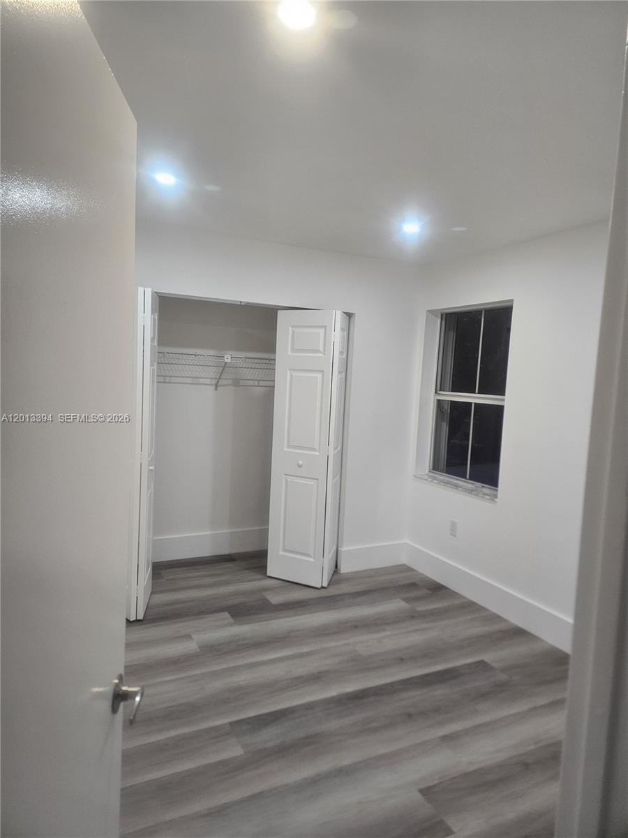 4010 Tree Top Road, Unit 4010 Cooper City, FL 33026 - Photo 10 of 12 a view of an empty room with wooden floor and a window