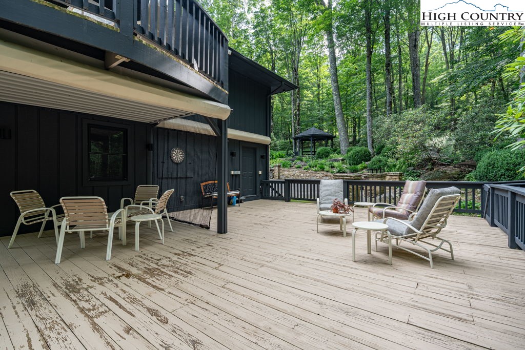 102 Ridge Drive Linville, NC 28646 - Photo 46 of 48 a view of a roof deck with table and chairs floor to ceiling window with wooden floor