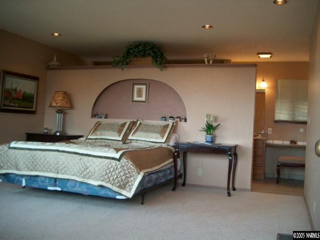 14630 Virginia Foothills Drive Reno, NV 89521 - Photo 2 of 9 a spacious bedroom with a bed and a table in it