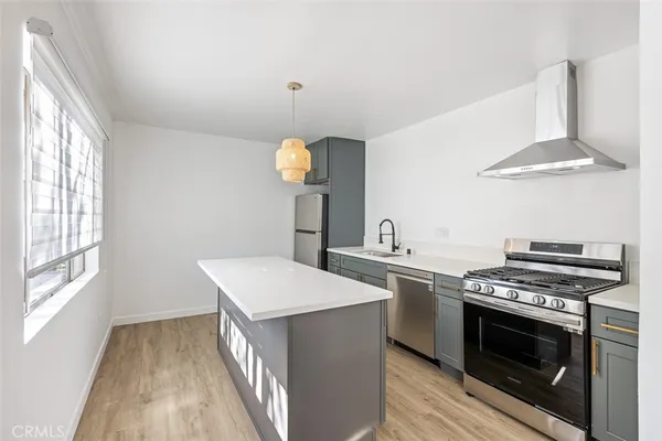a kitchen with stainless steel appliances a stove a sink and a refrigerator