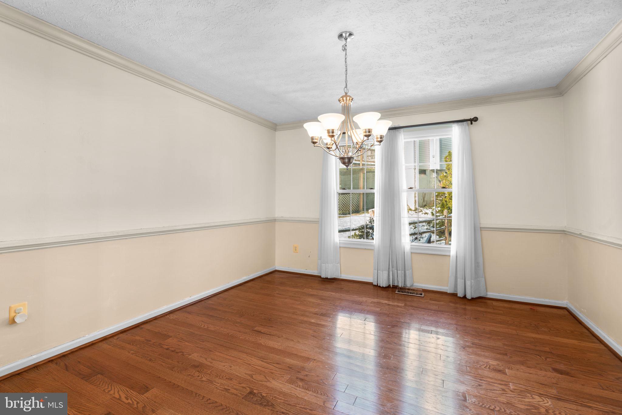 9464 Joppa Pond Road Baltimore, MD 21234 - Photo 11 of 66 a view of empty room with wooden floor and chandelier