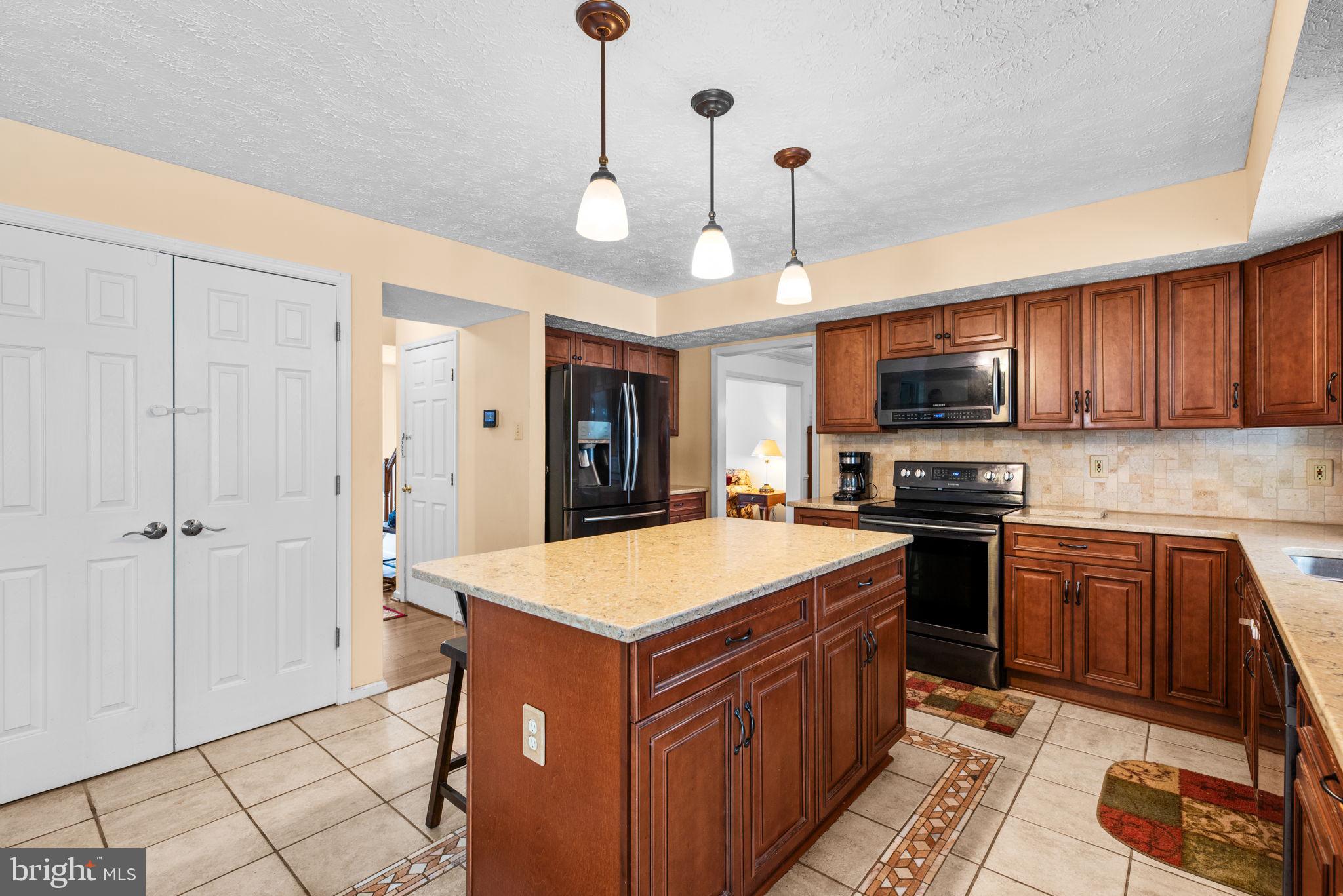 9464 Joppa Pond Road Baltimore, MD 21234 - Photo 17 of 66 a kitchen with kitchen island granite countertop stainless steel appliances cabinets a sink and a counter top space