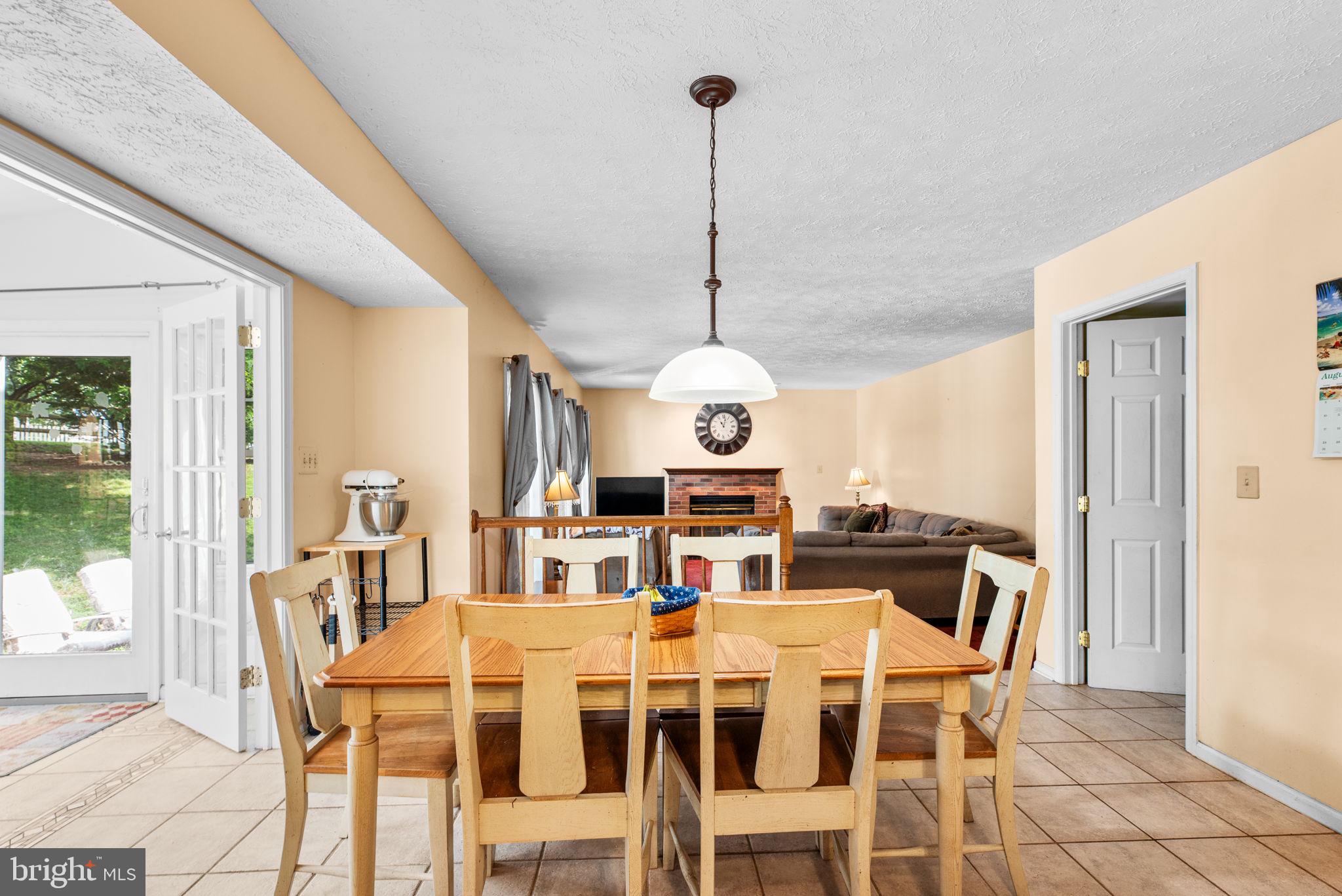 9464 Joppa Pond Road Baltimore, MD 21234 - Photo 19 of 66 a dining room with furniture a chandelier and wooden floor
