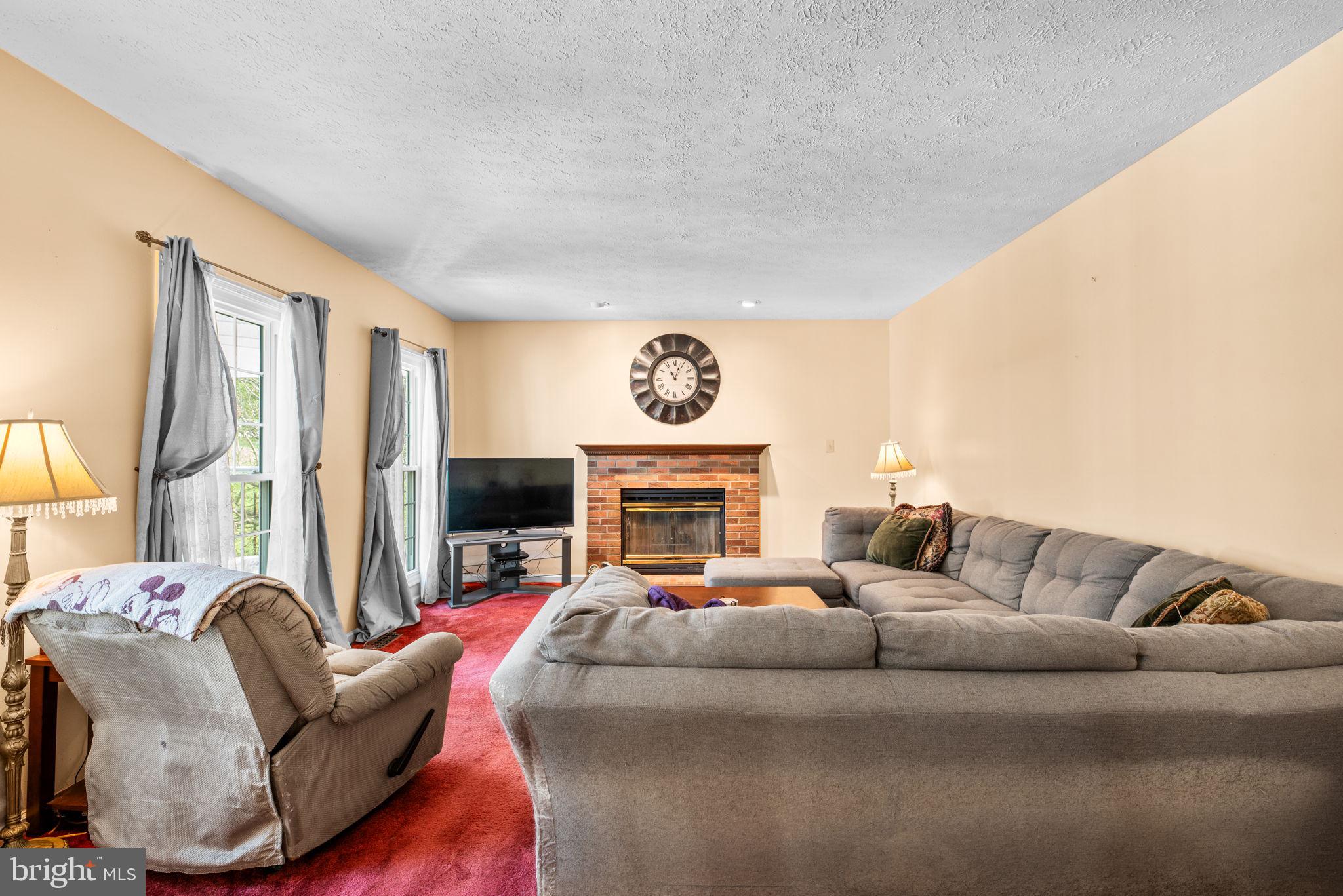 9464 Joppa Pond Road Baltimore, MD 21234 - Photo 21 of 66 a living room with furniture a fireplace and a flat tv screen