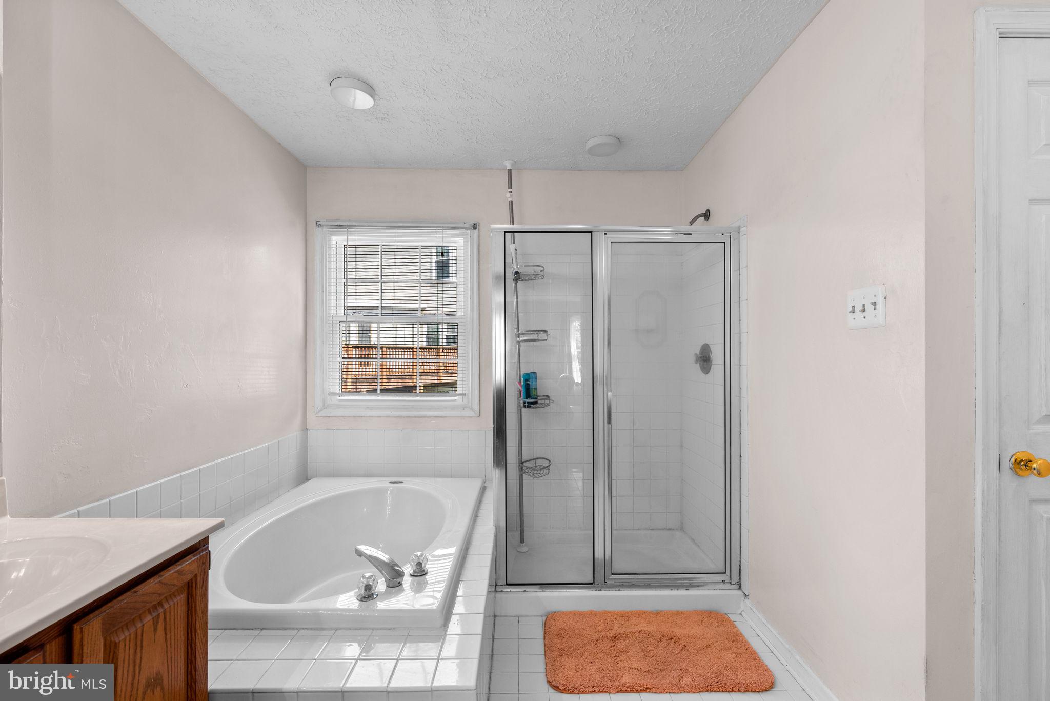 9464 Joppa Pond Road Baltimore, MD 21234 - Photo 37 of 66 a bathroom with a tub shower and window