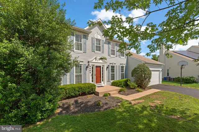 a front view of a house with a yard and potted plants