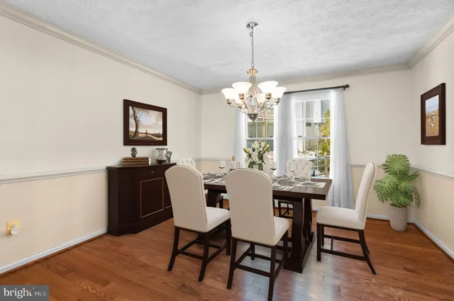 a view of a dining room with furniture a chandelier and wooden floor