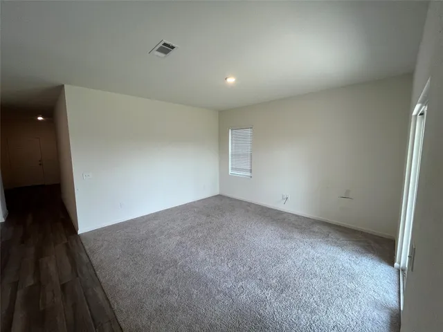 an empty room with wooden floor and entrance