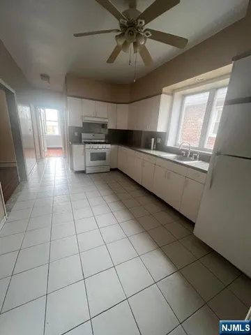 a kitchen with stainless steel appliances kitchen island granite countertop a refrigerator and a stove top oven