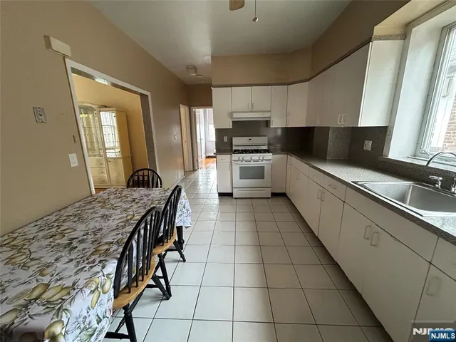 a kitchen with stainless steel appliances kitchen island granite countertop a sink counter space cabinets and a stove