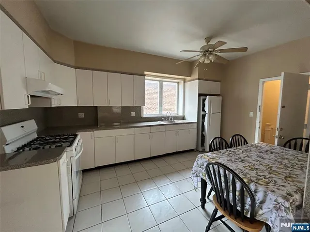 a kitchen with a sink a stove cabinets and a window