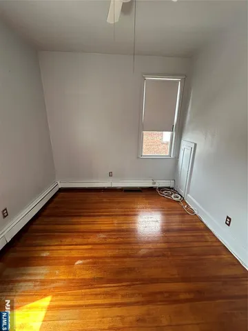 a view of room with window and wooden floor