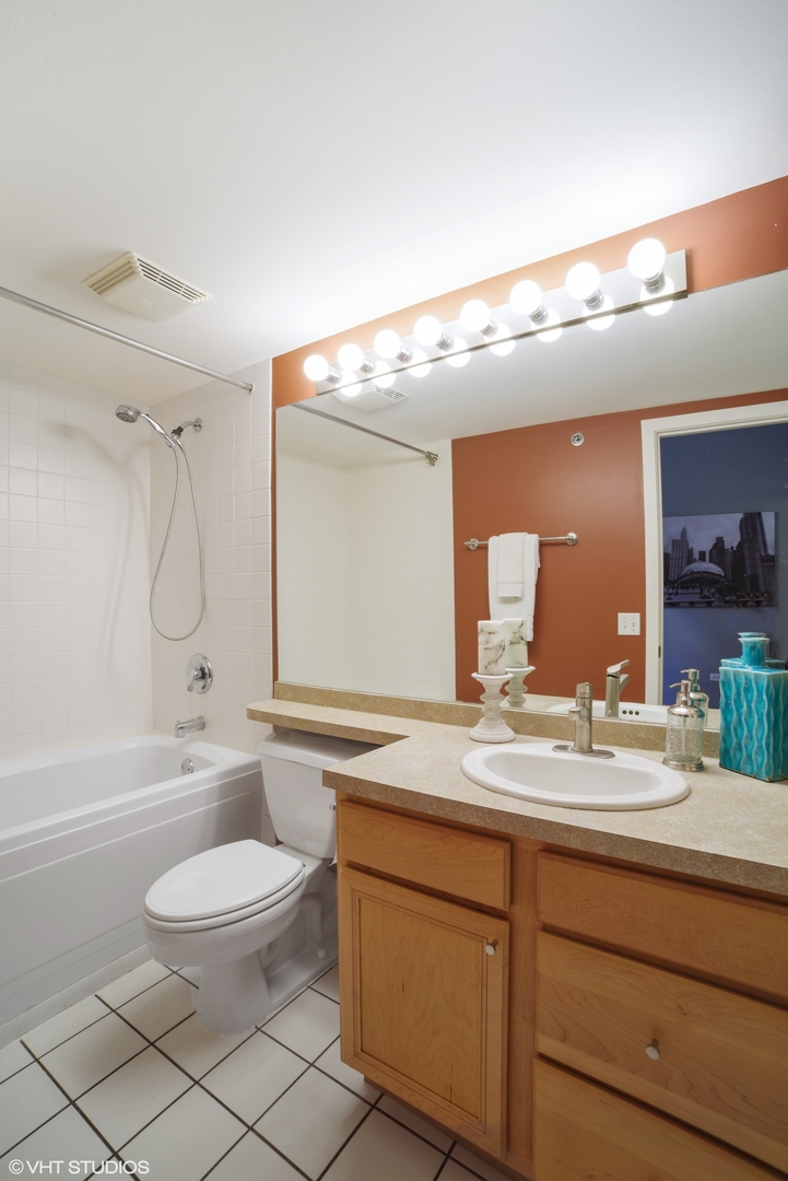 500 South Clinton Street, Unit 217 Chicago, IL 60607 - Photo 11 of 11 a bathroom with a double vanity sink toilet mirror and bathtub