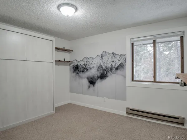 a view of a bedroom with a bed and a window