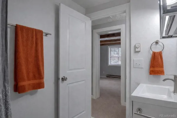 a bathroom with a toilet sink vanity and mirror