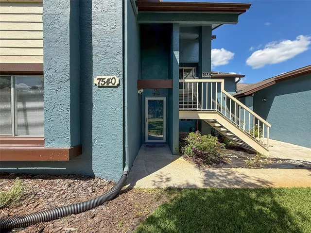 a view of a house with a small yard and wooden floor and fence