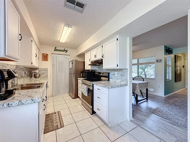 a kitchen with stainless steel appliances granite countertop a sink and a refrigerator