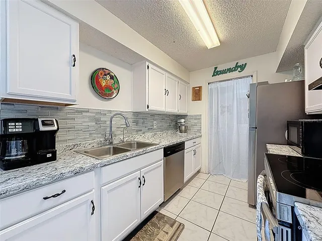 a large kitchen with stainless steel appliances granite countertop a stove and a sink