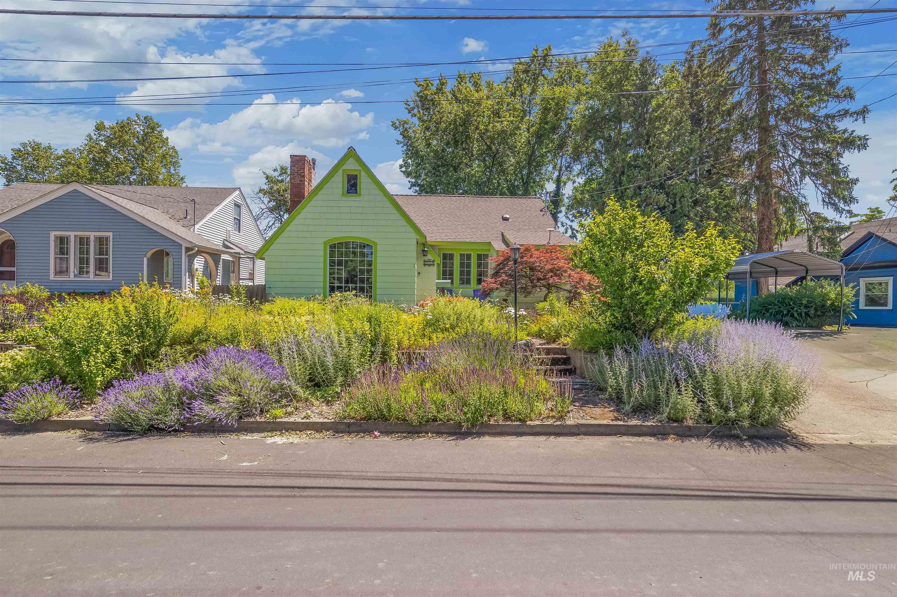 924 N Street Lewiston, ID 83501 - Photo 45 of 46 Front exterior featuring a vibrant green facade, a prominent arched window, and a gabled roofline with a brick chimney