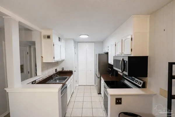 a kitchen with stainless steel appliances a stove a microwave a sink and cabinets