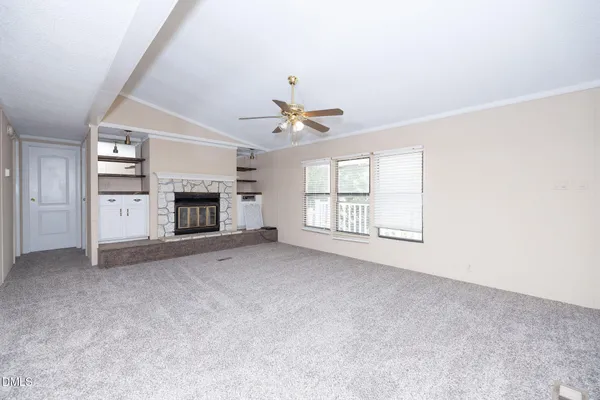an empty room with fireplace and windows