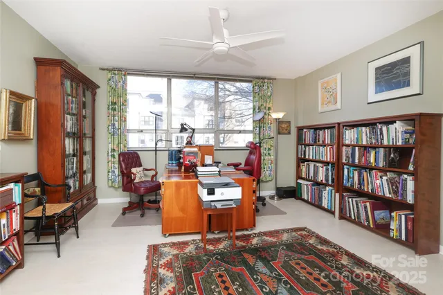 a view of a livingroom with workspace and a bookshelf