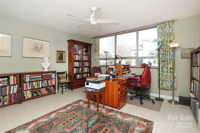 a view of a workspace with furniture and a window