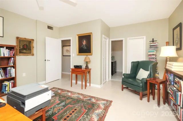 a living room with furniture and a dining table with bookshelf