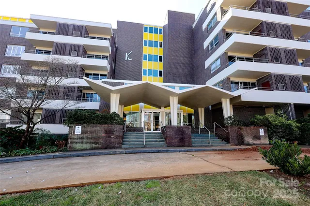 a front view of a multi story building with yard