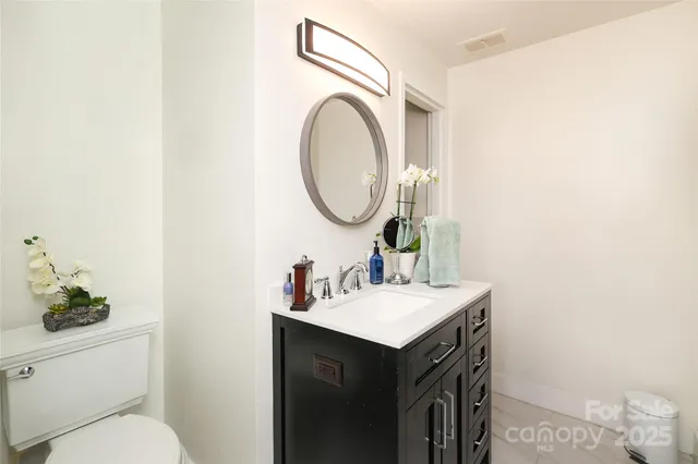 a bathroom with a sink a toilet and a mirror