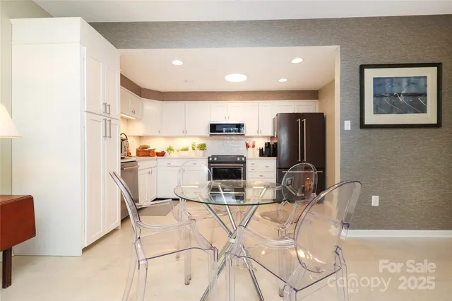 a view of kitchen with stainless steel appliances furniture refrigerator and microwave