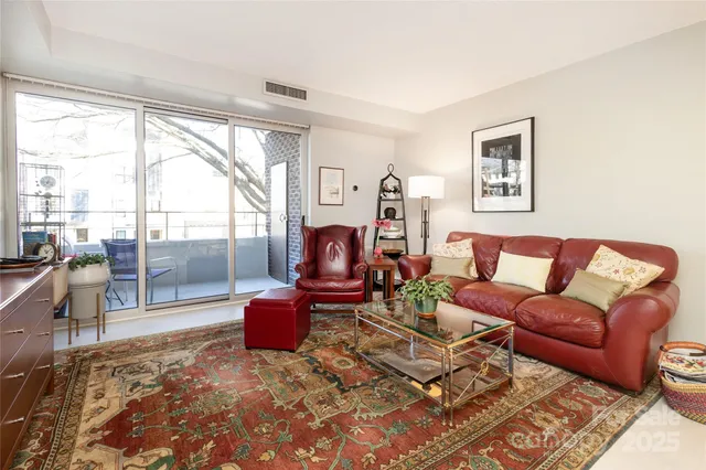a living room with furniture a flat screen tv and a floor to ceiling window