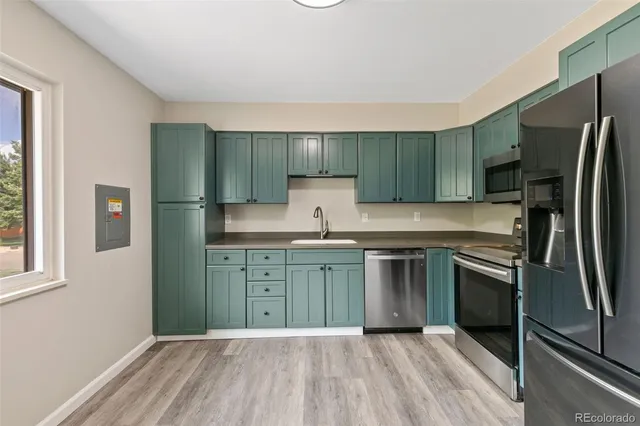 a kitchen with a refrigerator an oven and cabinets