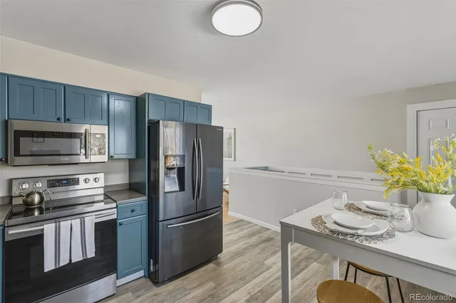 a kitchen with stainless steel appliances granite countertop a refrigerator a stove a sink and a microwave