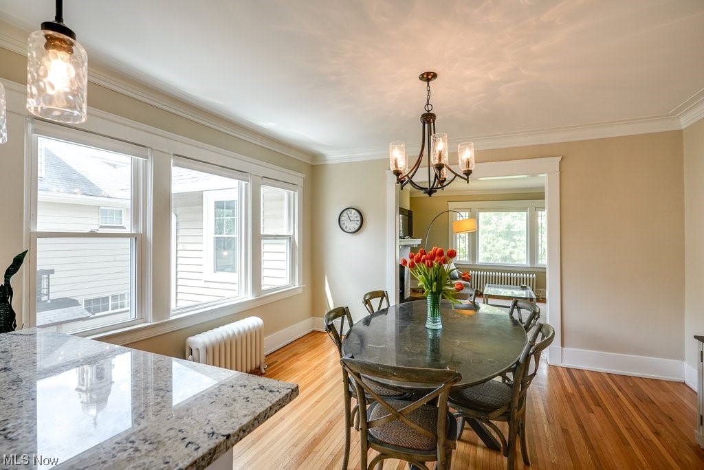 2135 Renrock Road Cleveland, OH 44118 - Photo 22 of 44 Dining room featuring a notable chandelier, light wood-type flooring, ornamental molding, and radiator heating unit