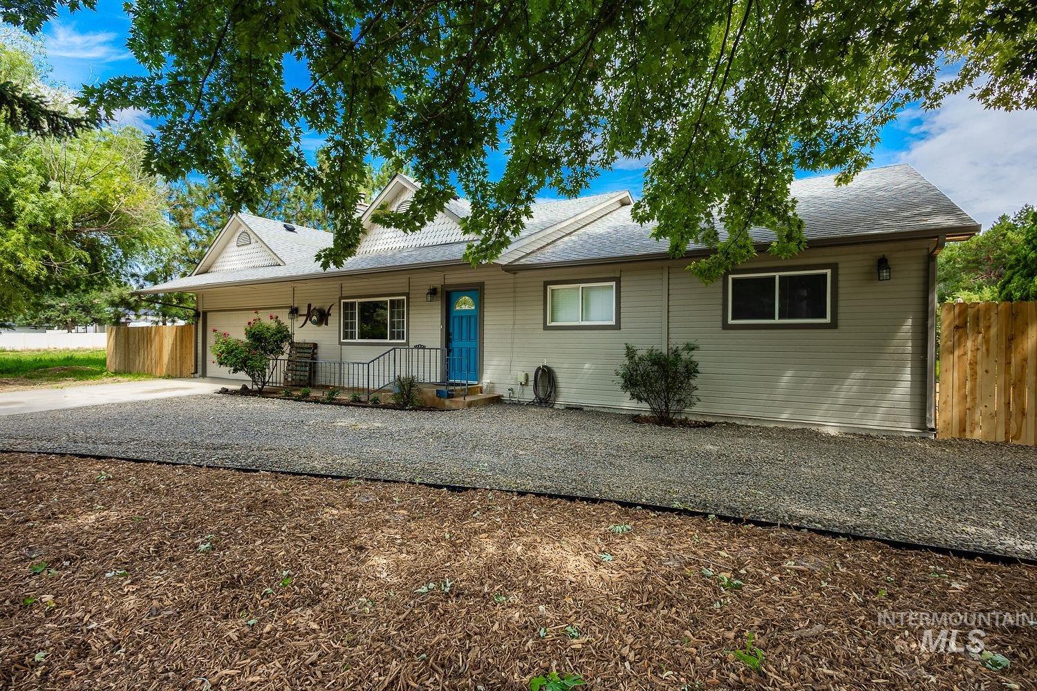 7166 South Cloverdale Road Boise, ID 83709 - Photo 1 of 50 Single-story exterior with light gray siding, a blue entry door, and white trim windows