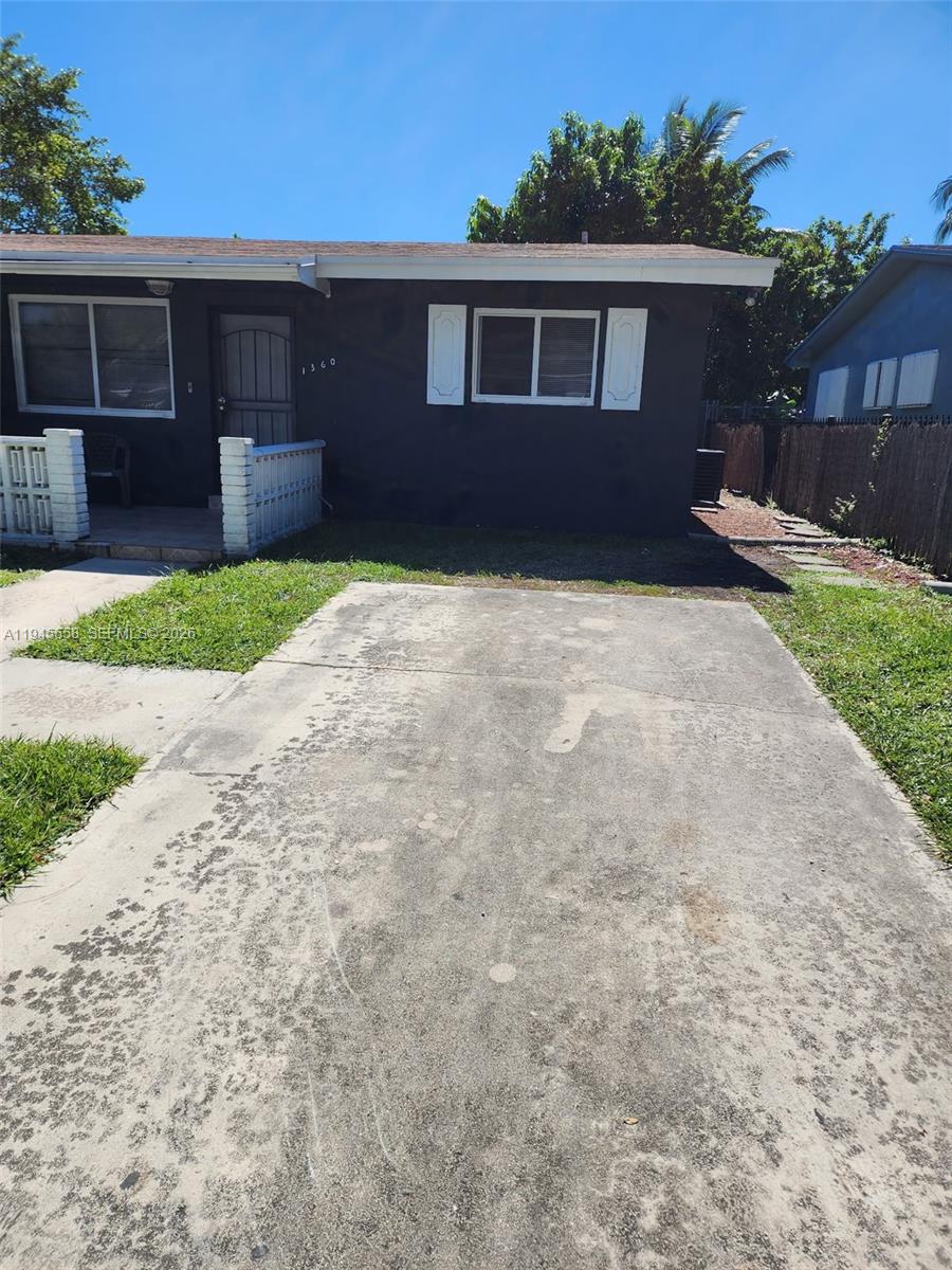 1360 Northeast 144th Street, Unit 3 Miami, FL 33161 - Photo 1 of 12 a front view of a house with a yard and garage