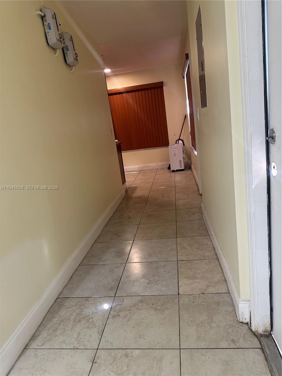 1360 Northeast 144th Street, Unit 3 Miami, FL 33161 - Photo 4 of 12 a view of a hallway with wooden floor and glass door