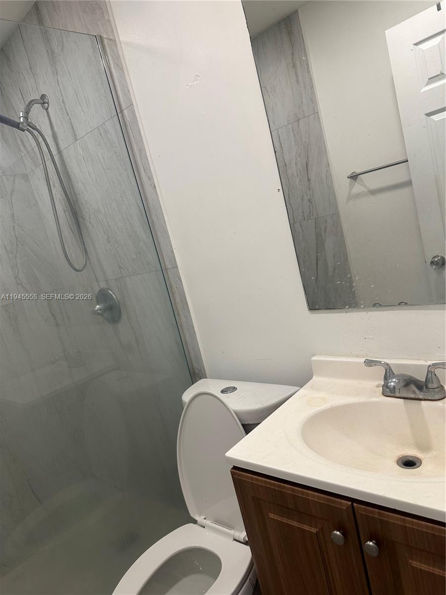 1360 Northeast 144th Street, Unit 3 Miami, FL 33161 - Photo 7 of 12 a bathroom with a sink a toilet and a mirror