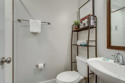 a bathroom with a sink toilet and mirror